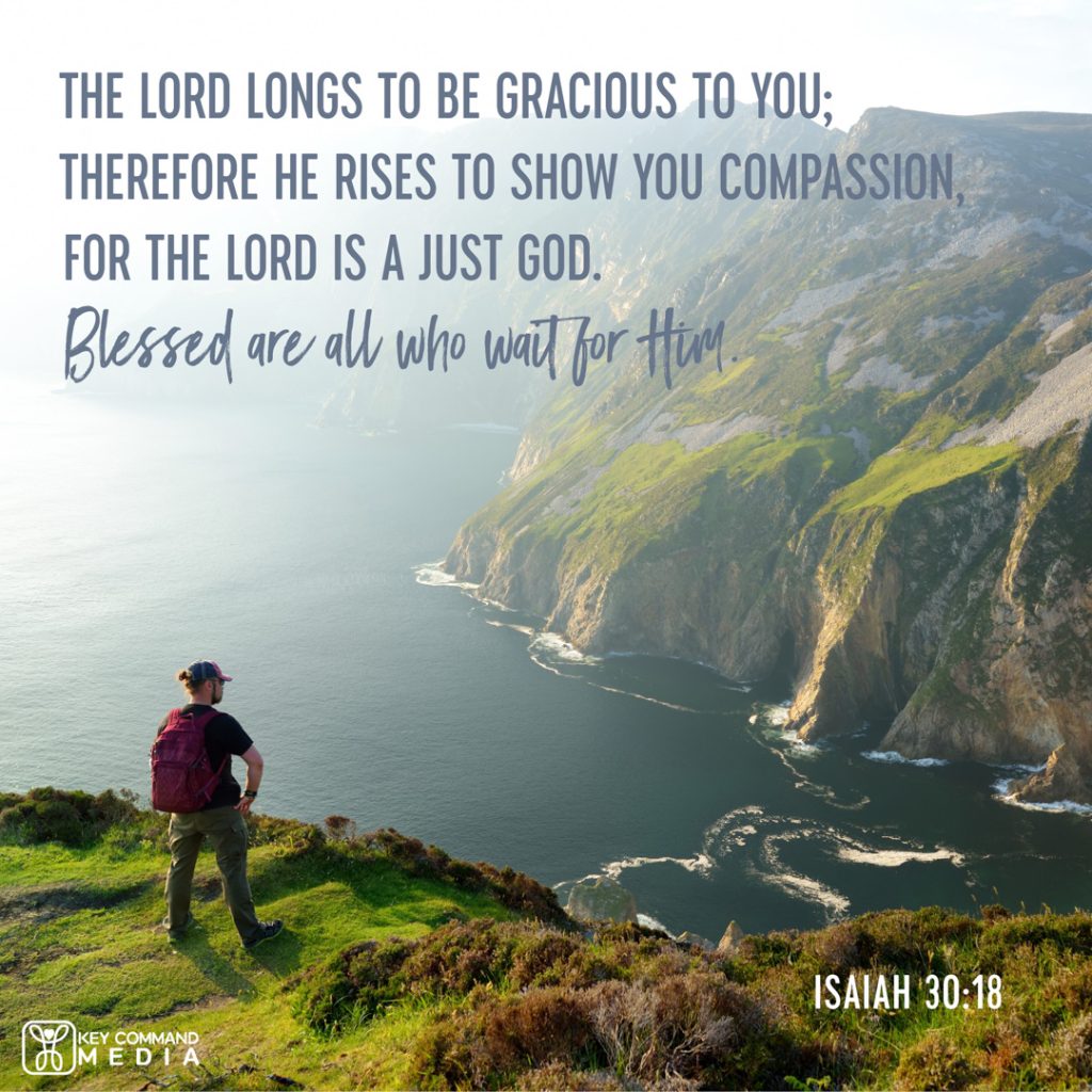 A backer looks out across a cliff by the sea with Isaiah 30:18, "The Lord longs to be gracious to you; therefore He rises to show you compassion, for the Lord is a just God. Blessed are all who wait for Him."