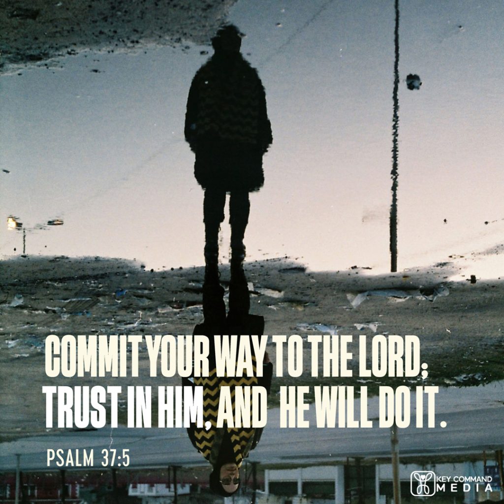 A woman standing on pavement is reflected by a puddle in the opposite direction with Psalm 37:5, "Commit your way to the Lord; trust in Him, and He will do it."