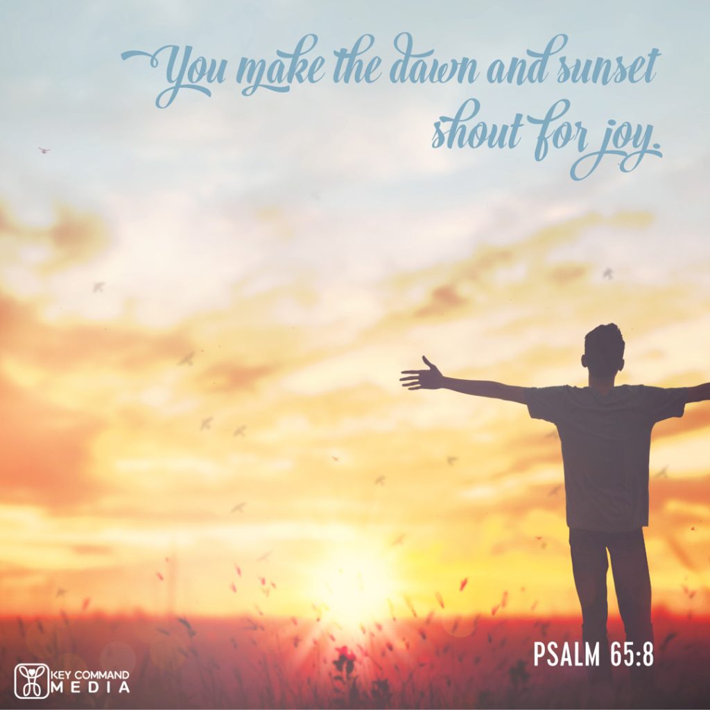 A young man in silhouette stands with arms outstretched again the rising sun in a wheat field with Psalm 65:8 "You make the dawn and sunset shout for joy."