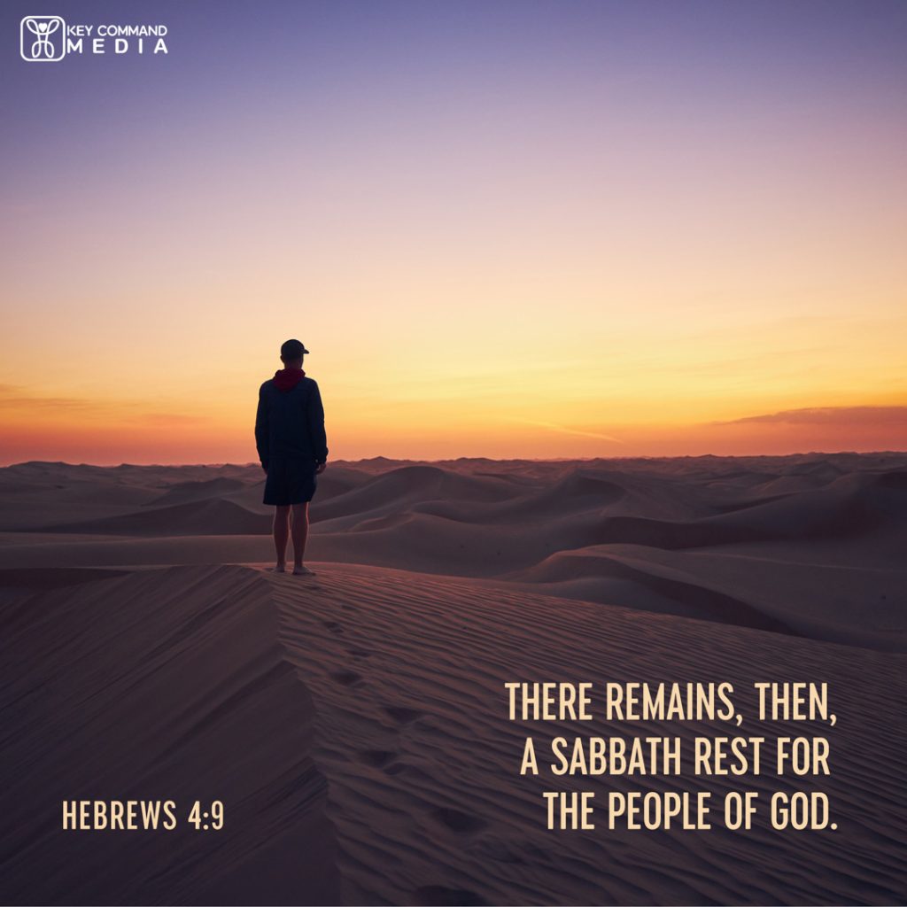 A silhouetted man in a hoodie, shorts, and a ball cap stands on a sand dune amidst a sea of desert sand as the sun sets with Hebrews 4:9, "There remains, then, a Sabbath rest for the people of God."