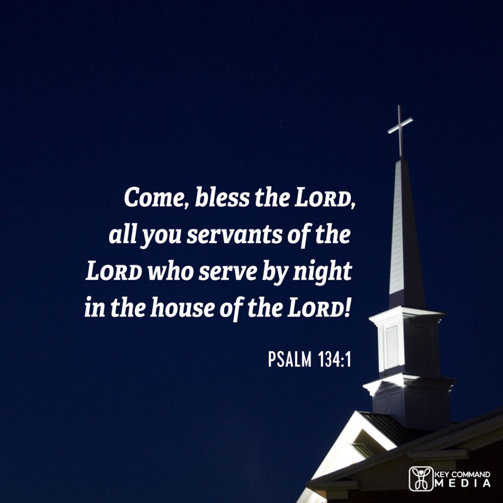 A white church steeple is illuminated by a floodlight in the dark sky with Psalm 134:1, "Come, bless the Lord, all you servants of the Lord who serve by night in the house of the Lord!"