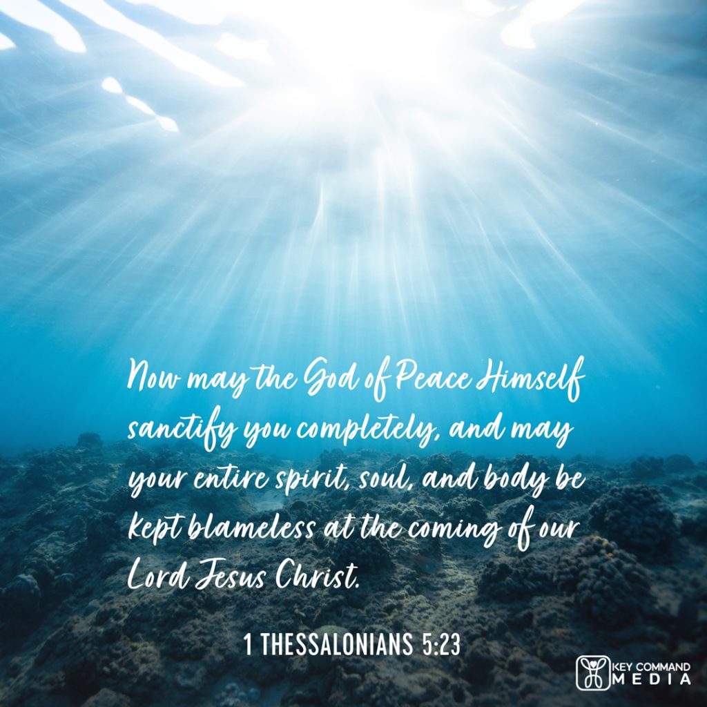 Light streams through the ocean water illuminating the coral floor underneath with 1 Thessalonians 5:23, "Now may the God of Peace Himself sanctify you completely, and may your entire spirit, soul, and body be kept blameless at the coming of our Lord Jesus Christ."