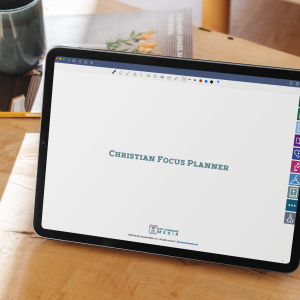 The Christian Focus Planner cover page is displayed on an upright iPad Pro on a wooden table with a cup of coffee in the background